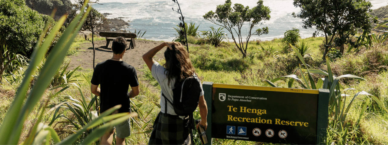 Two people walking in Te Henga Bethells Beach in Auckland