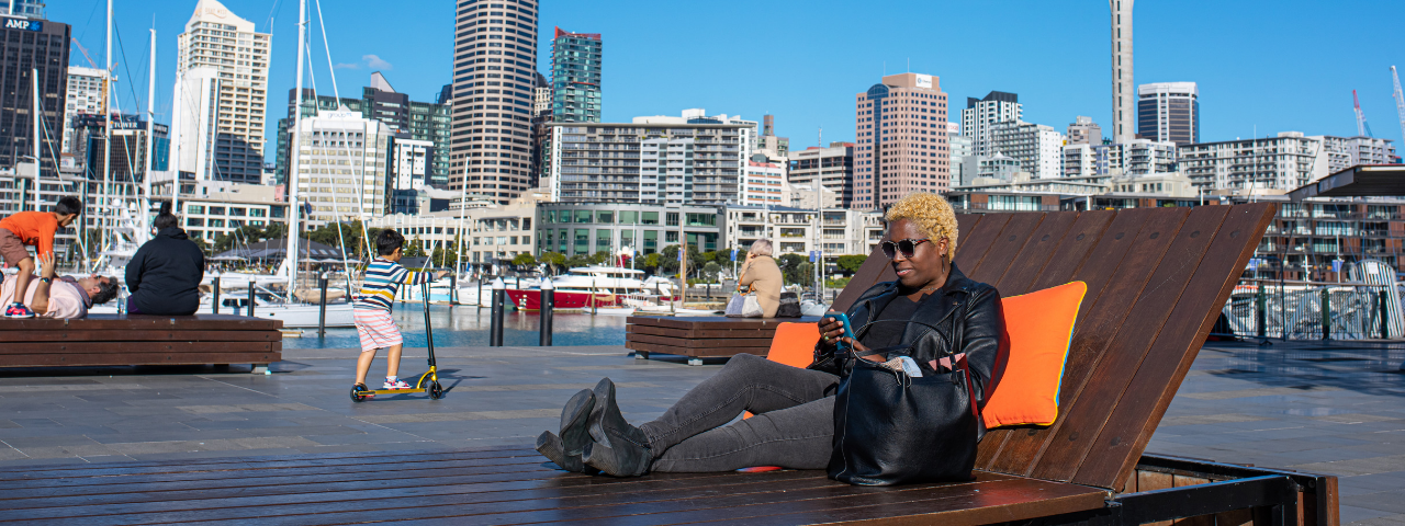Woman sitting on the large wooden sun loungers at Wynard Quarter