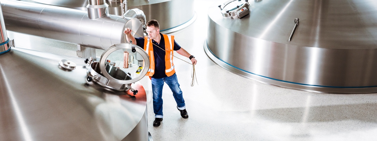 Man in high-vis vest works in industrial setting