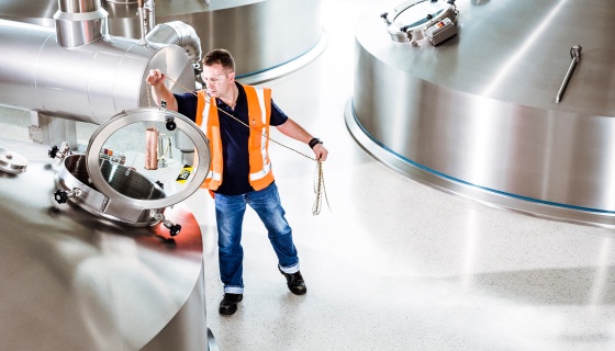 Man in high-vis vest works in industrial setting